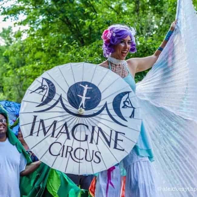 Liz Bliss winged stilt walker in parade with Paperhand Puppet | Imagine Circus