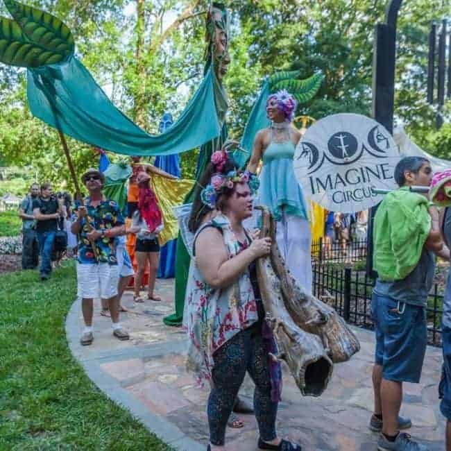 Stilt Walker in parade with Paperhand Puppet | Liz Bliss | Imagine Circus